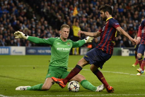 Manchester City's goalkeeper Joe Hart (L) blocks Barcelona's Cesc Fabregas during their Champions League round of 16 first leg soccer match at the Etihad Stadium in Manchester, northern England February 18, 2014.