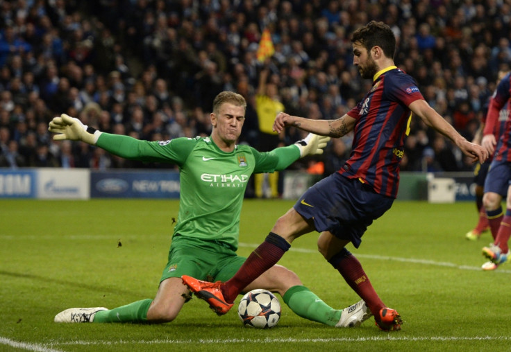 Manchester City's goalkeeper Joe Hart (L) blocks Barcelona's Cesc Fabregas during their Champions League round of 16 first leg soccer match at the Etihad Stadium in Manchester, northern England February 18, 2014.