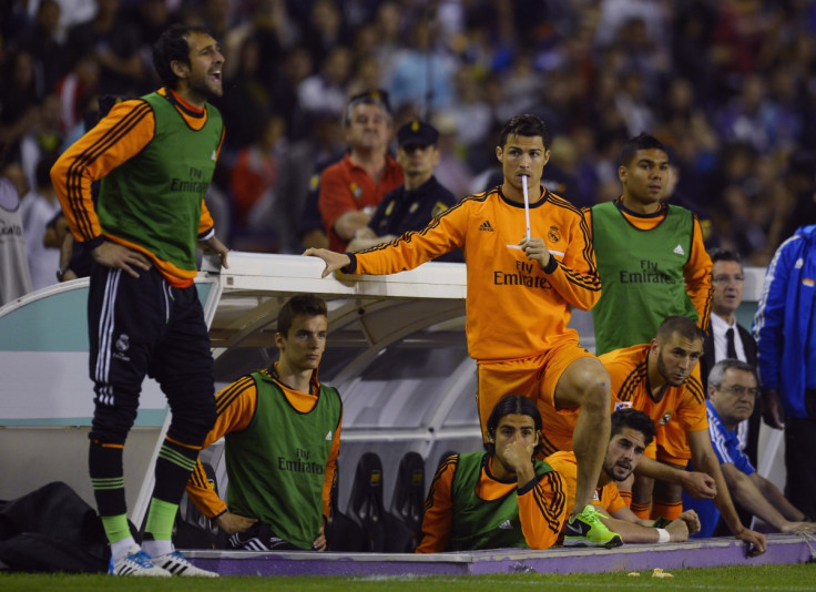 Real Madrid's Cristiano Ronaldo (C) and teammates watch their Spanish First Division soccer match against Valladolid from the bench, at Zorrilla Stadium in Valladolid May 7, 2014.