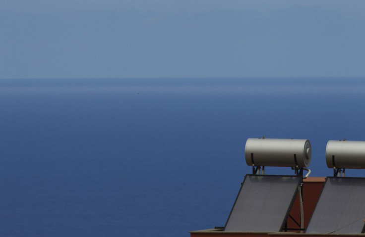 Solar panels are seen on the rooftop of a house near the sea in Santa Cruz de Tenerife.