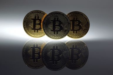 Mock Bitcoins are displayed on a table in an illustration picture