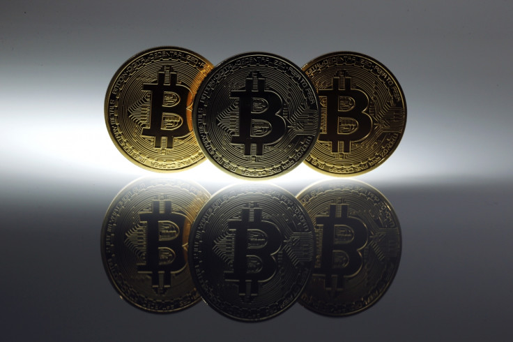 Mock Bitcoins are displayed on a table in an illustration picture