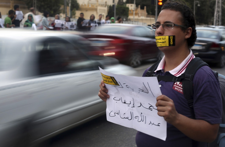 A demonstrator looks on with a sign reading "I am against the military courts for civilians