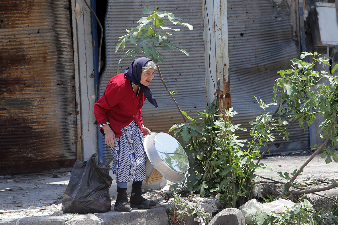 A woman retrieves belongings from her home in the Old City