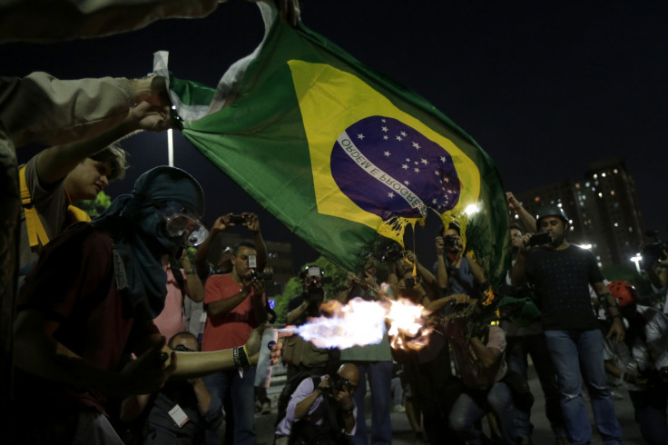 Demonstrators burn a Brazilian flag during a protest against the 2014 World Cup in Rio de Janeiro