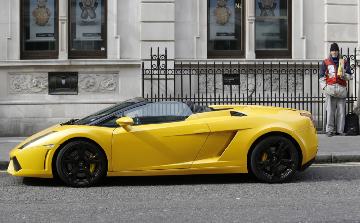 A homeless man sells a copy of The Big Issue nest to a Lamborghini sports car in central London. (Reuters)
