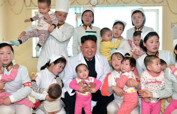 Kim Jung Un poses with (presumably) loyal young pioneers following apartment block collapse disaster