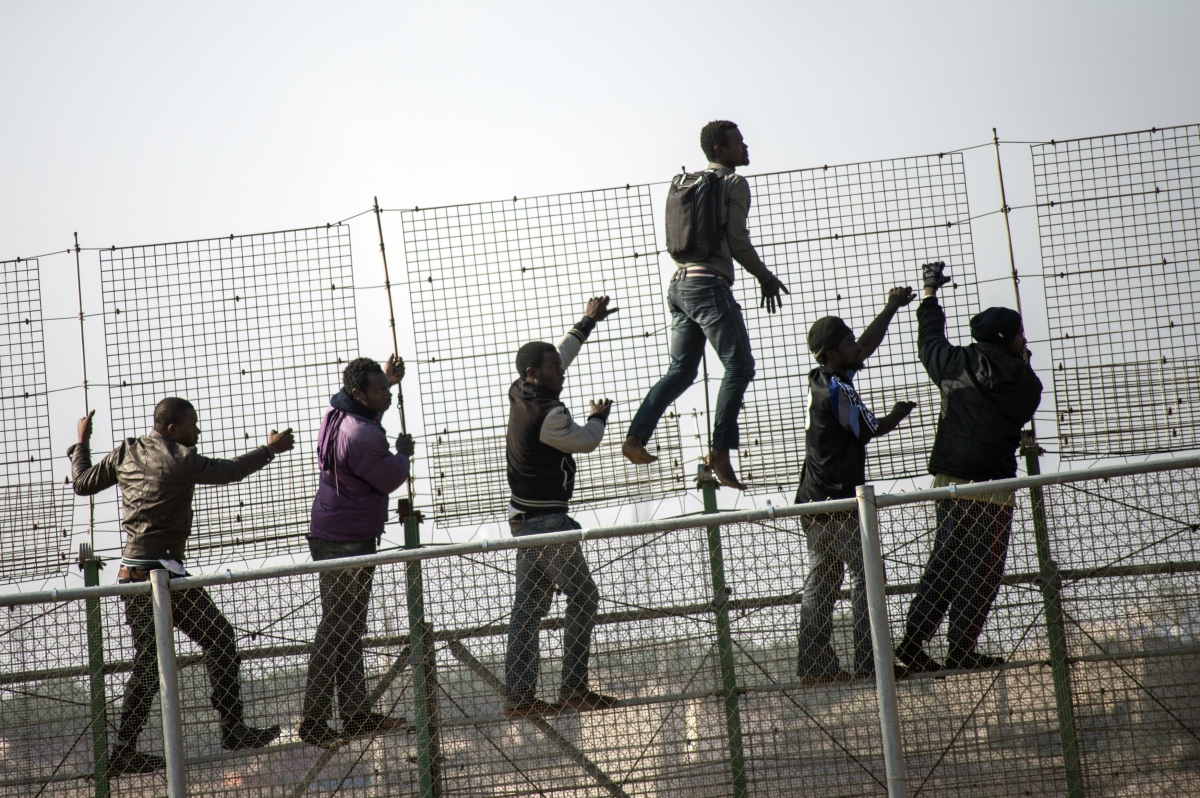 African migrants climb a border fence covered in razor wire during their latest attempt to cross into Spanish territory between Morocco and Spain's north African enclave of Melilla African migrants climb a border fence covered in razor wire during their latest attempt to cross into Spanish territory between Morocco and Spain's north African enclave of Melilla
