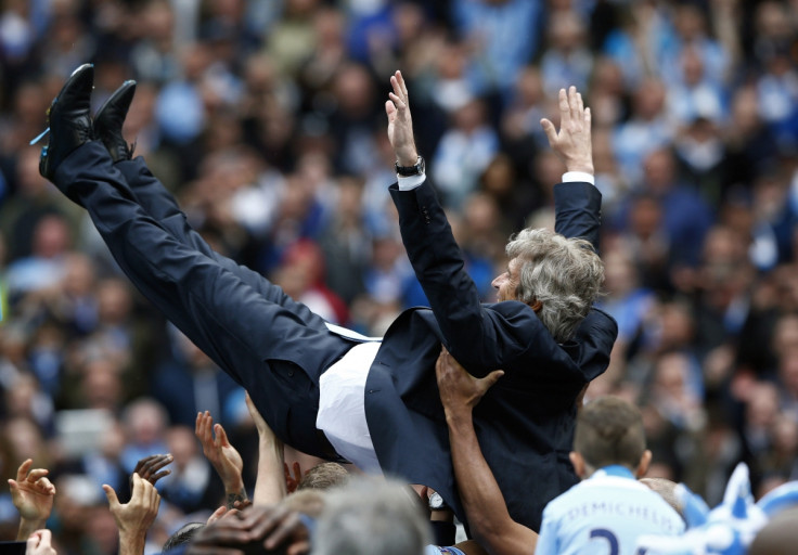 Manchester City's manager Manuel Pellegrini is thrown into the air by his team as they celebrate winning the English Premier League trophy following their soccer match against West Ham United at the Etihad Stadium in Manchester, northern England May 11, 