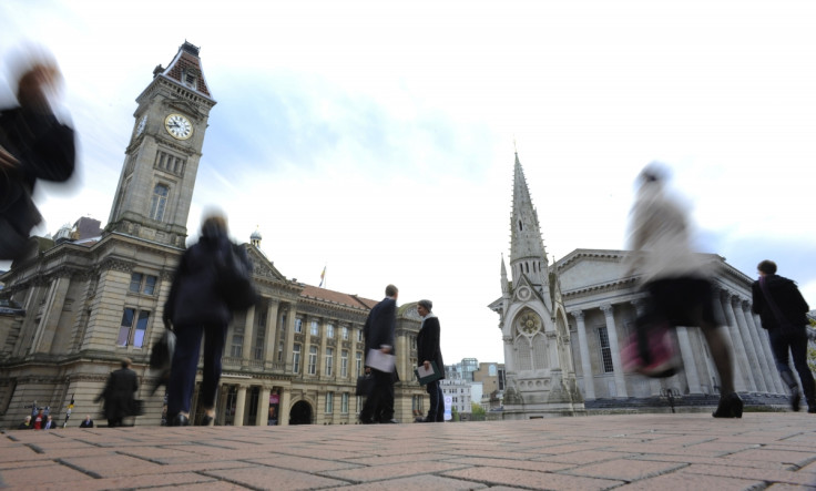 Commuters pass the Town Hall and Council House in Birmingham in central England