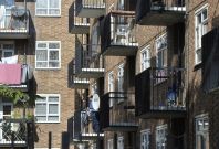 A man stands on a balcony in a residential high rise block of flats in Notting Hill in central London