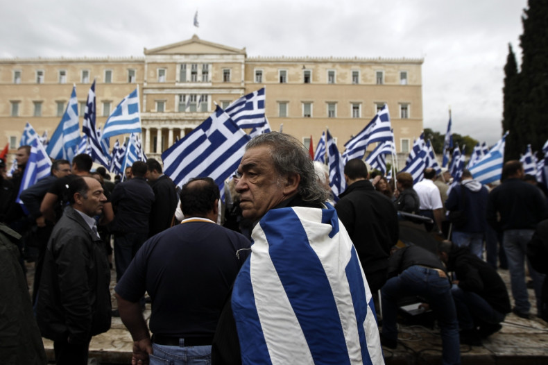 A supporter of Greece's far-right Golden Dawn wears a national flag on his back during a rally in front of the Greek Parliament in Athens