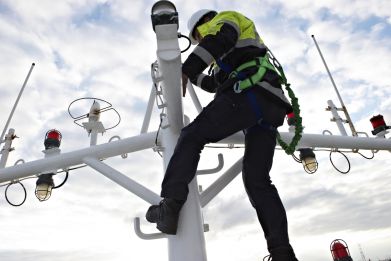 Imtech Service technician climbing in a mast to perform service on a antenna.
