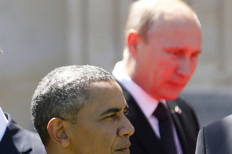 Red light reflected from the carpet illuminates Russian President Vladimir Putin as he passes U.S. President Barack Obama at a group photo for the 70th anniversary of the D-Day landings in Benouville