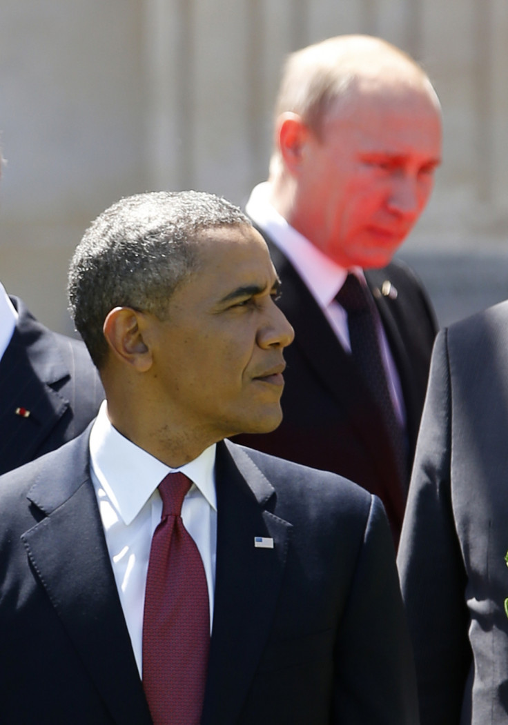 Red light reflected from the carpet illuminates Russian President Vladimir Putin as he passes U.S. President Barack Obama at a group photo for the 70th anniversary of the D-Day landings in Benouville