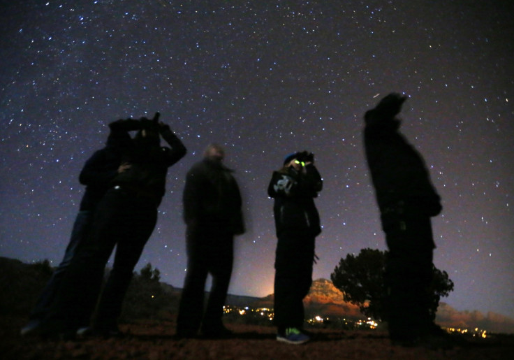 People use night vision goggles to look at the night sky during an Unidentified Flying Object (UFO) tour