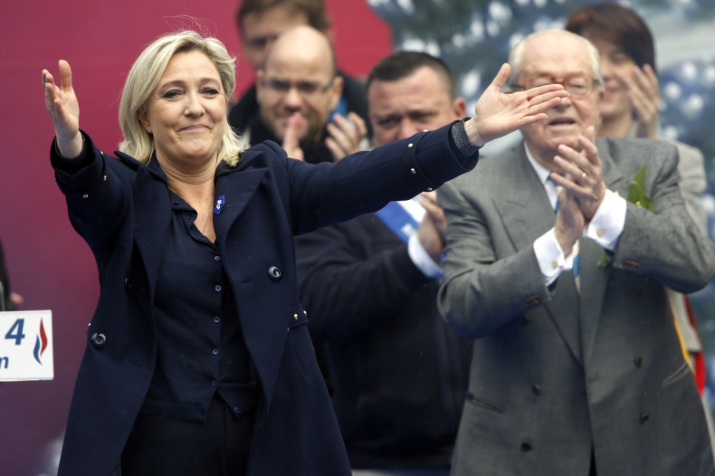 France's far right National Front political party leader Marine Le Pen (L) gestures at supporters next to her father Jean-Marie Le Pen