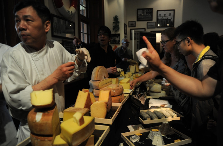 Chinese people sampling cheese at a market.