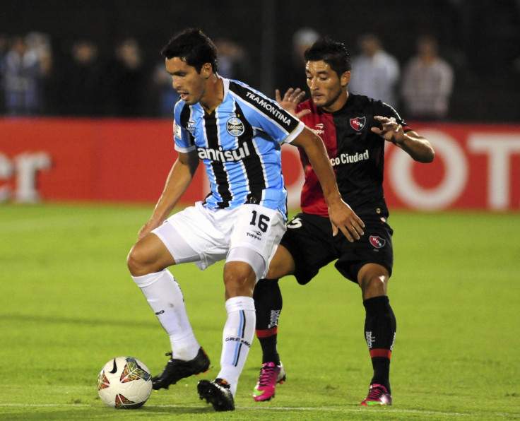 Milton Casco of Argentina's Newell's Old Boys (R) challenges Bressan of Brazil's Gremio during their Copa Libertadores soccer match in Rosario March 19, 2014.
