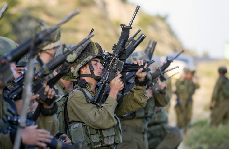 Israeli soldiers load their weapons before taking part in an operation to locate three Israeli teens near the West Bank City of Hebron