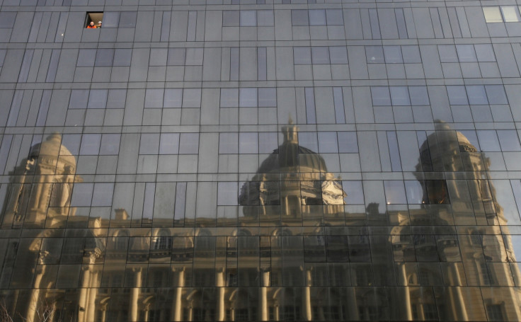 Workmen look out of a window in the new Mann Island apartment development as the Port of Liverpool building is reflected in the glass, in Liverpool, northern England February 14, 2011.