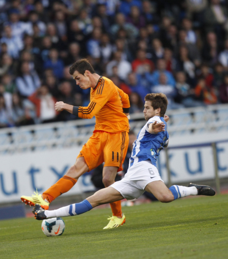 Real Madrid's Gareth Bale fights for the ball with Real Sociedad's Inigo Martinez during their La Liga soccer match at Anoeta stadium in San Sebastian April 5, 2014