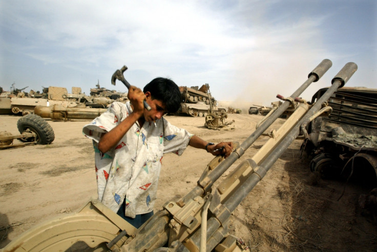 An Iraqi man recovers metal parts from an anti-aircraft gun in a wreckage dump on the outskirts of Baghdad
