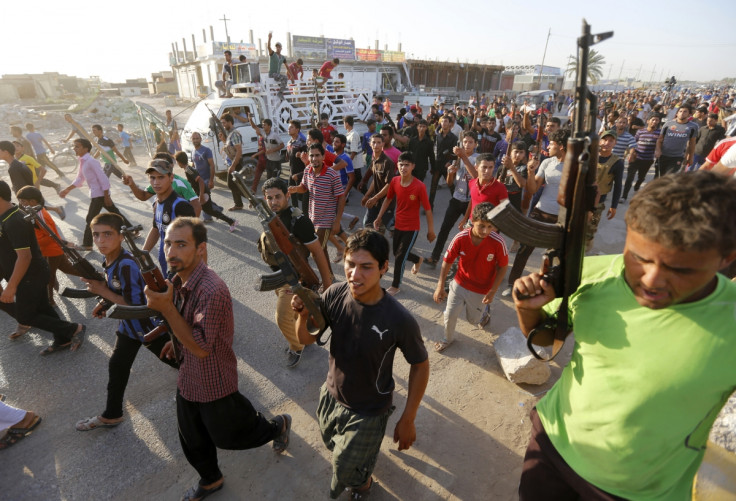 Volunteers, who have joined the Iraqi Army to fight against predominantly Sunni militants from the radical Islamic State of Iraq and the Levant (ISIL), carry weapons during a parade in the streets in Al-Fdhiliya district, eastern Baghdad