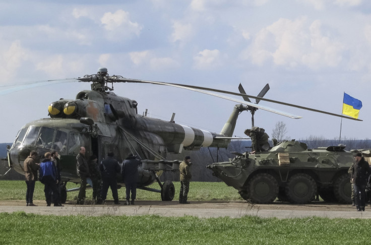 Ukrainian soldiers are seen near a MI-8 military helicopter