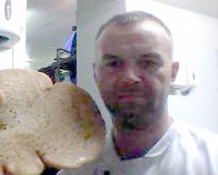 Scott Mcmillan poses with baked creation before sacking by Donald Trump
