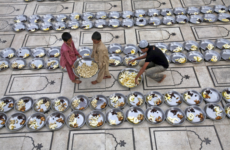 Volunteers prepare plates of food at the mosque for Iftar, the evening meal