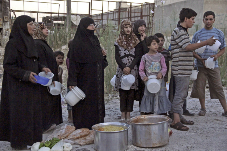 People wait for the time for the Iftar meal to break their fast in Aleppo, Syria