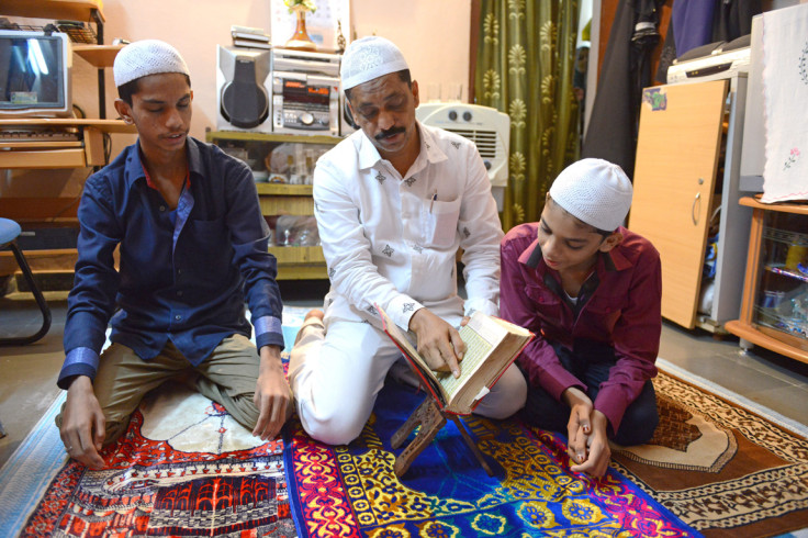 An Indian Muslim family reads the Quran after breaking their fast at their home in Hyderabad, India