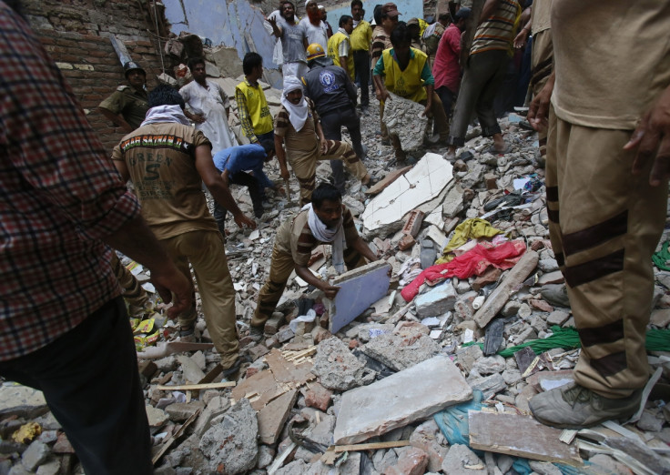 Rescue workers clear the debris from the site of a collapsed building in New Delhi