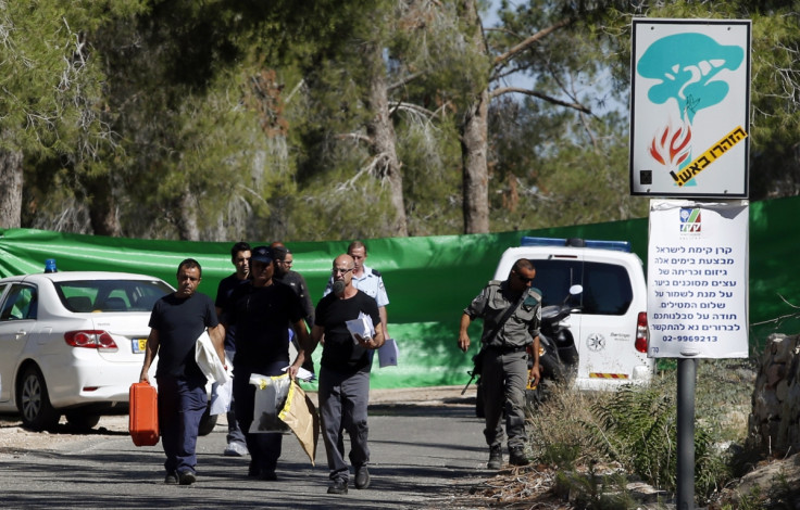 Israeli police crime scene investigators carry evidence from the scene where a body was found in the Jerusalem Forest