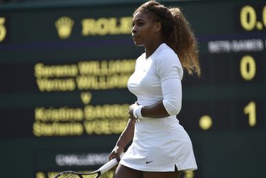 Serena Williams of the U.S. holds her stomach before retiring from her women's doubles tennis match with Venus Williams of the U.S. against Kristina Barrois of Germany and Stefanie Voegele of Switzerland at the Wimbledon Tennis Championships, in London J
