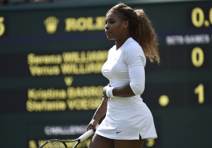 Serena Williams of the U.S. holds her stomach before retiring from her women's doubles tennis match with Venus Williams of the U.S. against Kristina Barrois of Germany and Stefanie Voegele of Switzerland at the Wimbledon Tennis Championships, in London J