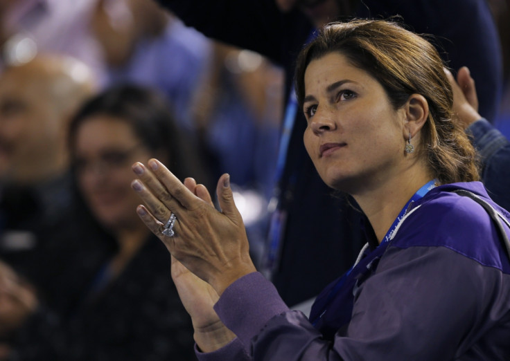 Mirka Federer, wife of Roger Federer of Switzerland, applauds as he gives an interview after he defeated Jo-Wilfried Tsonga of France in their men's singles quarter-final match at the Australian Open tennis tournament