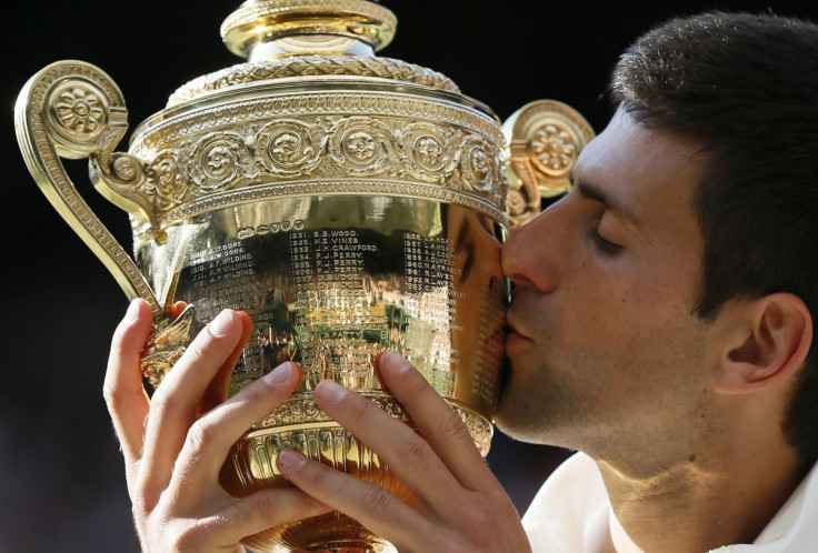 Novak Djokovic of Serbia kisses the winner's trophy after defeating Roger Federer of Switzerland in their men's singles finals tennis match on Centre Court at the Wimbledon Tennis Championships in London July 6, 2014.