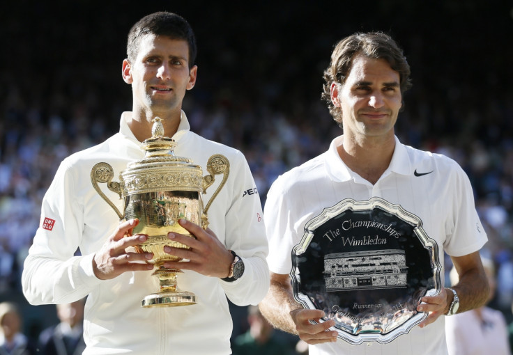 Novak Djokovic of Serbia holds the winner's trophy after defeating Roger Federer (R) of Switzerland, holding the runner-up's trophy, in their men's singles finals tennis match on Centre Court at the Wimbledon Tennis Championships in London July 6, 2014