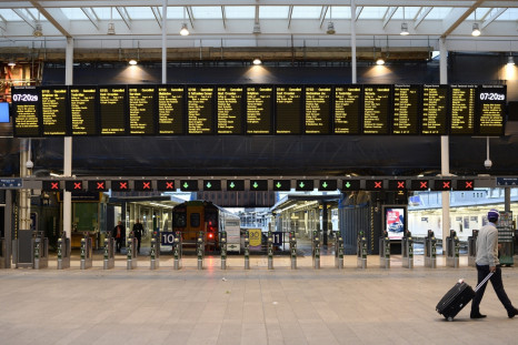 A lone commuter walks past the notice board at London Bridge Station showing all trains cancelled during rush hour in London