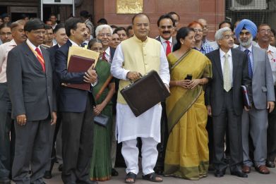India's Finance Minister Arun Jaitley (C) poses as he leaves his office to present the federal budget for the 2014/15 fiscal year, in New Delhi