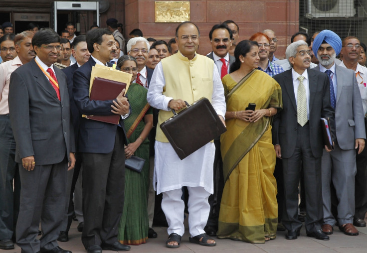 India's Finance Minister Arun Jaitley (C) poses as he leaves his office to present the federal budget for the 2014/15 fiscal year, in New Delhi