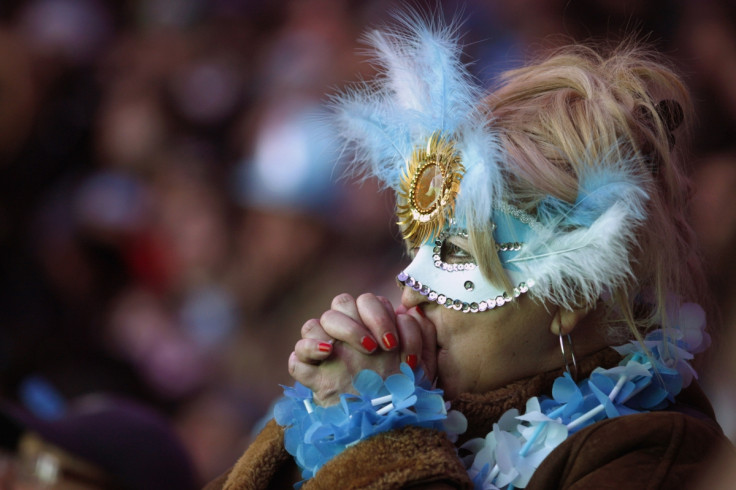 A masked fan holds her breath and prays for Argentina to beat Germany