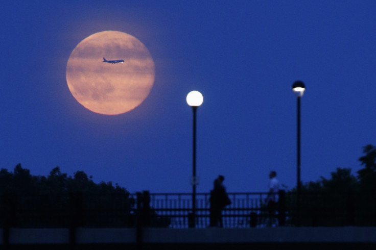 A plane passes in front of a Supermoon rising over the Rideau Canal in Ottawa, Canada