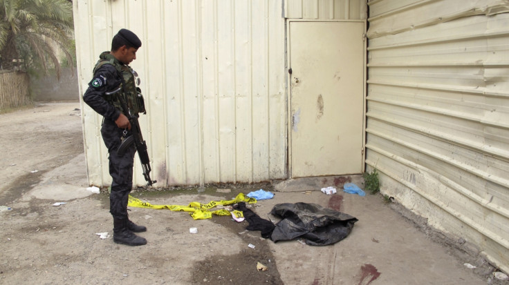 An Iraqi policeman looks at blood marks on the ground near an apartment building where a shooting occurred, in Baghdad (Reuters)