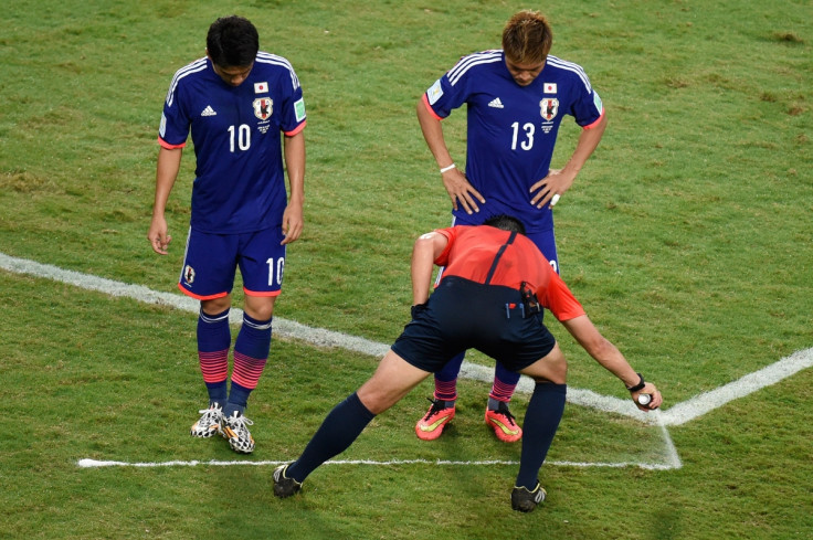 Portugues referee Pedro Proenca sprays a free kick line during a Group C football match between Japan and Colombia at the Fifa World Cup 2014