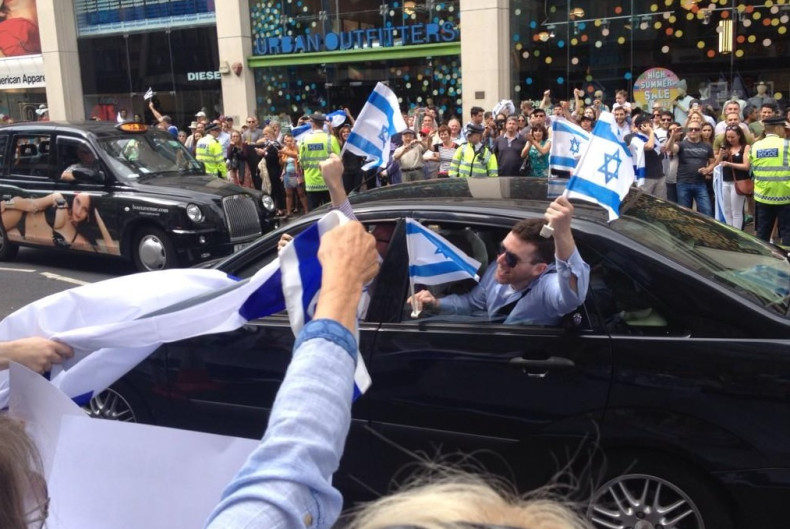 Protesters wave Israeli flags from a passing car at Sunday's pro-Israel demonstration.