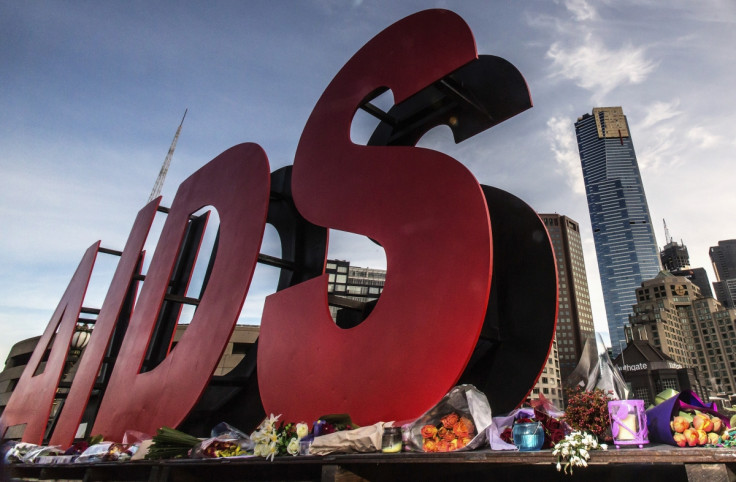 Flowers are laid as tributes to those killed in the Malaysia Airlines flight MH17, at the base of a large sign for the 20th International AIDS Conference in Melbourne July 20, 2014.