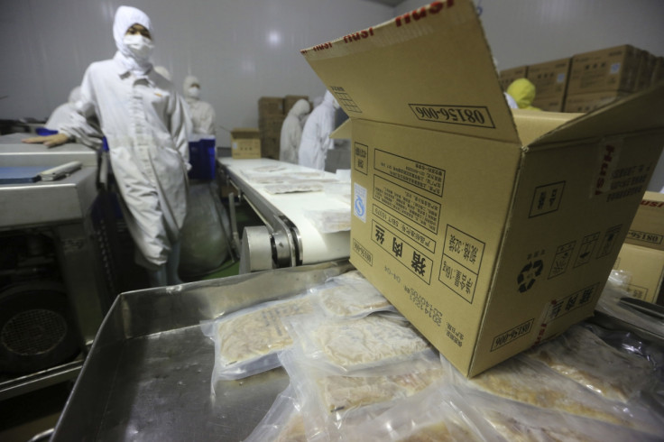 Employees work at a production line prior to a seizure conducted by officers from the Shanghai Food and Drug Administration, at the Husi Food factory in Shanghai, July 20, 201
